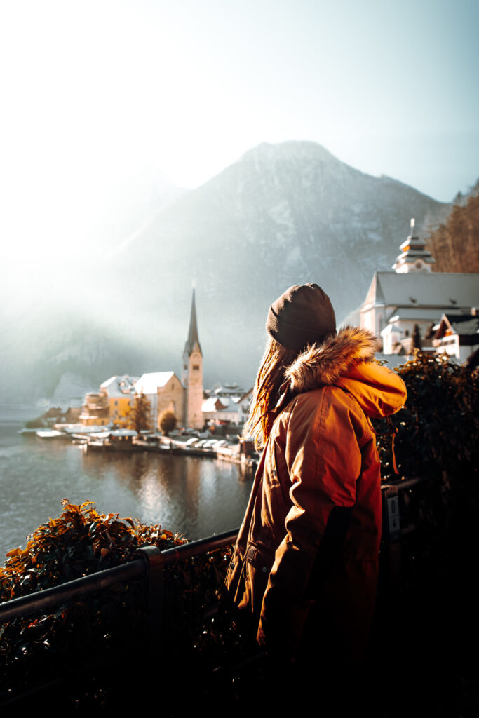 woman in orange jacket standing on brown wooden dock during daytime